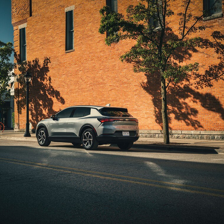 Chevrolet Blazer EV parked on a quiet urban street next to a brick building.