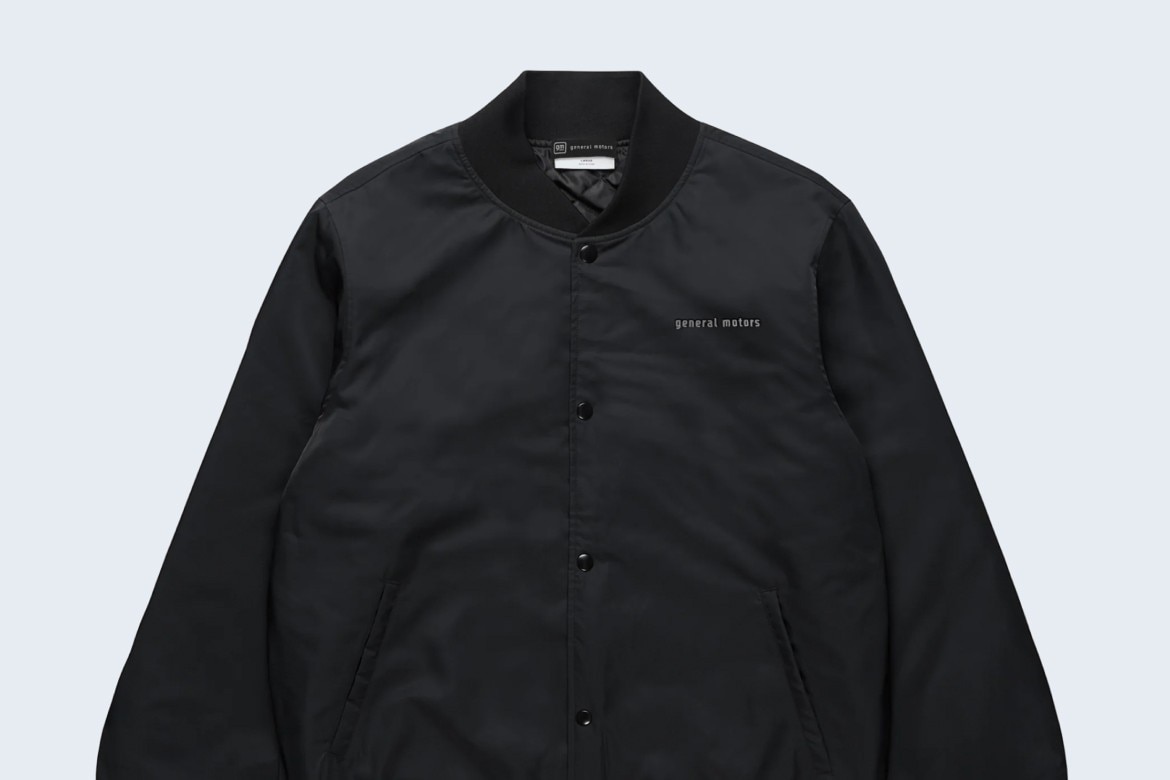 Black Collegiate Bomber Jacket With General Motors Text on Chest with Button-Up Front, Side Pickets, and Ribbed Cuffs.